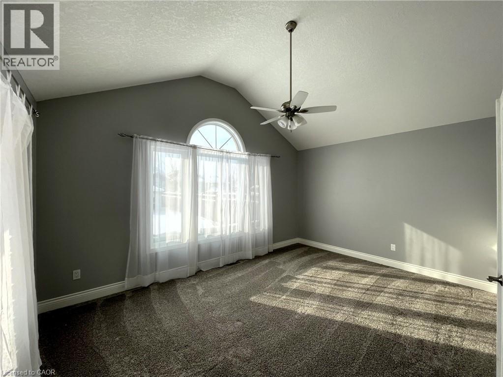 Carpeted spare room featuring vaulted ceiling, a textured ceiling, and a ceiling fan - 443 Lausanne Crescent, Waterloo, ON - Indoor Photo Showing Other Room