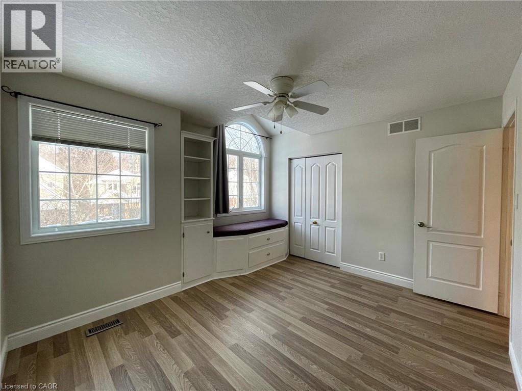 Unfurnished bedroom featuring a textured ceiling, light wood-style floors, a ceiling fan, and a closet - 443 Lausanne Crescent, Waterloo, ON - Indoor Photo Showing Other Room