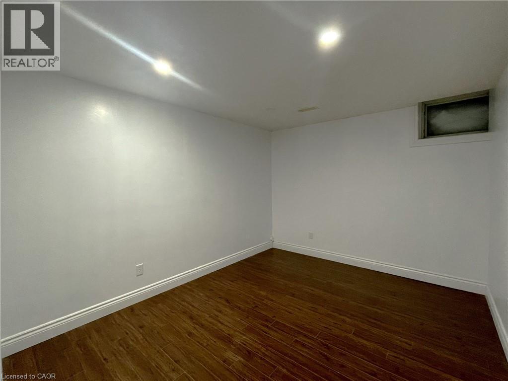 Unfurnished room with baseboards and dark wood-type flooring - 443 Lausanne Crescent, Waterloo, ON - Indoor Photo Showing Other Room