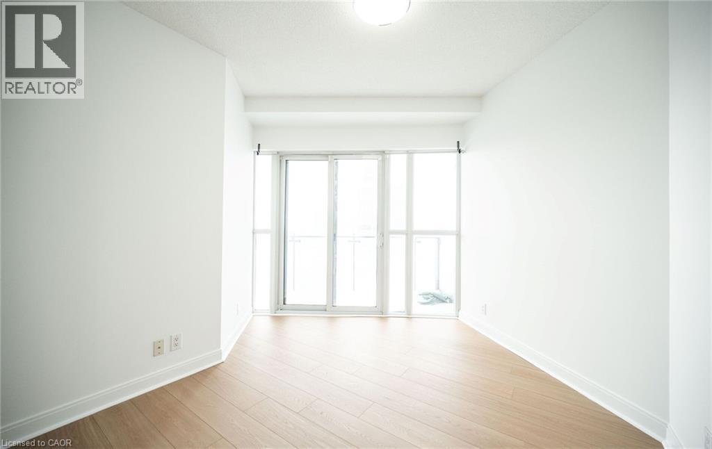 Spare room featuring light wood-style flooring and baseboards - 50 Absolute Avenue Unit# 2105, Mississauga, ON - Indoor Photo Showing Other Room