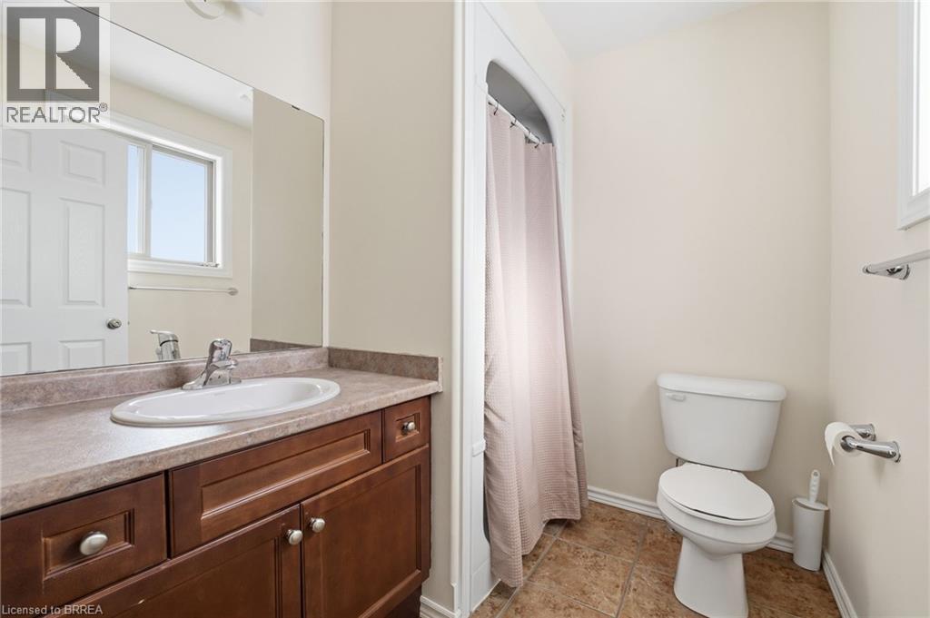 Full bath with a shower with curtain, vanity, and plenty of natural light - 28 Mansfield Drive, St. George, ON - Indoor Photo Showing Bathroom