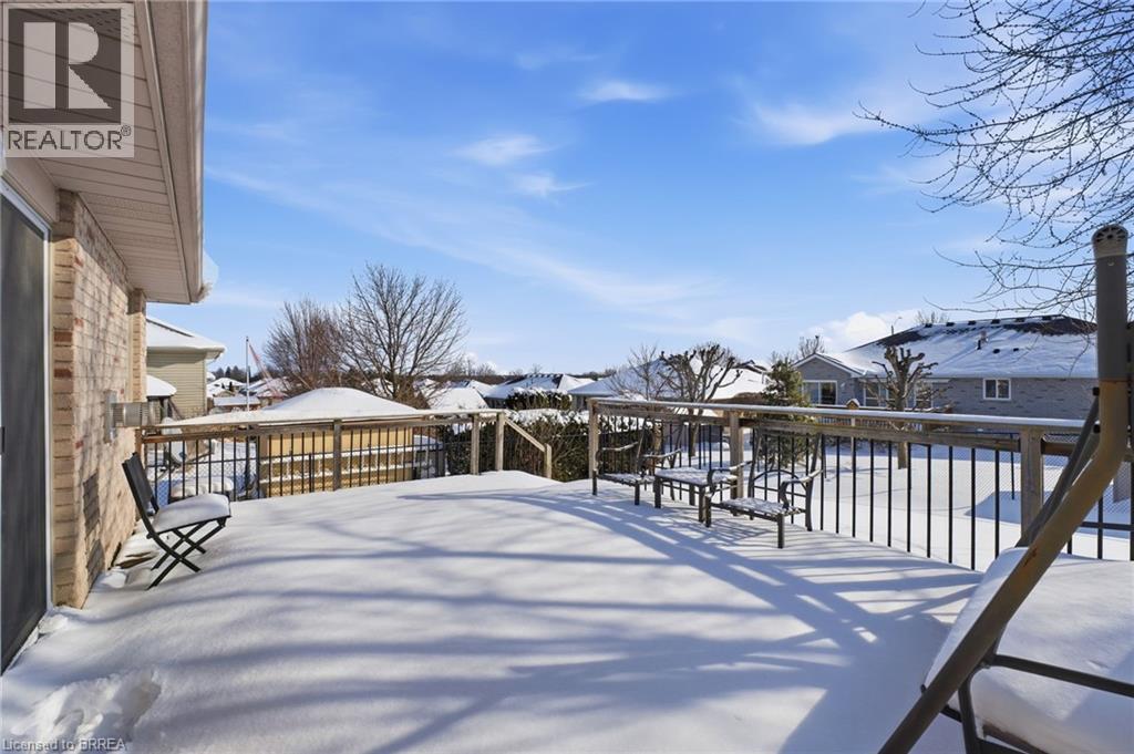 Yard layered in snow with a residential view and a wooden deck - 28 Mansfield Drive, St. George, ON - Outdoor