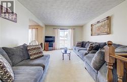 Carpeted living area featuring a textured ceiling -