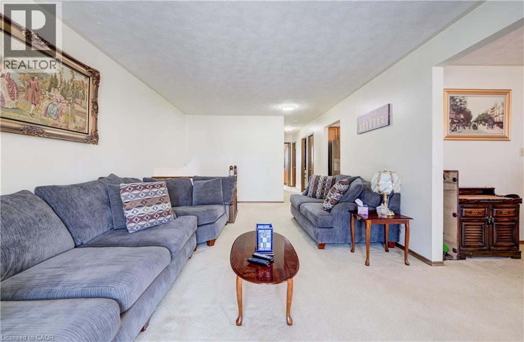 Living room featuring carpet flooring and a textured ceiling - 42 Ruffian Road, Brantford, ON - Indoor Photo Showing Living Room