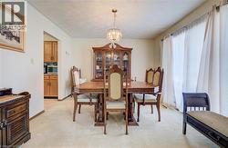 Dining room with a chandelier and light carpet -