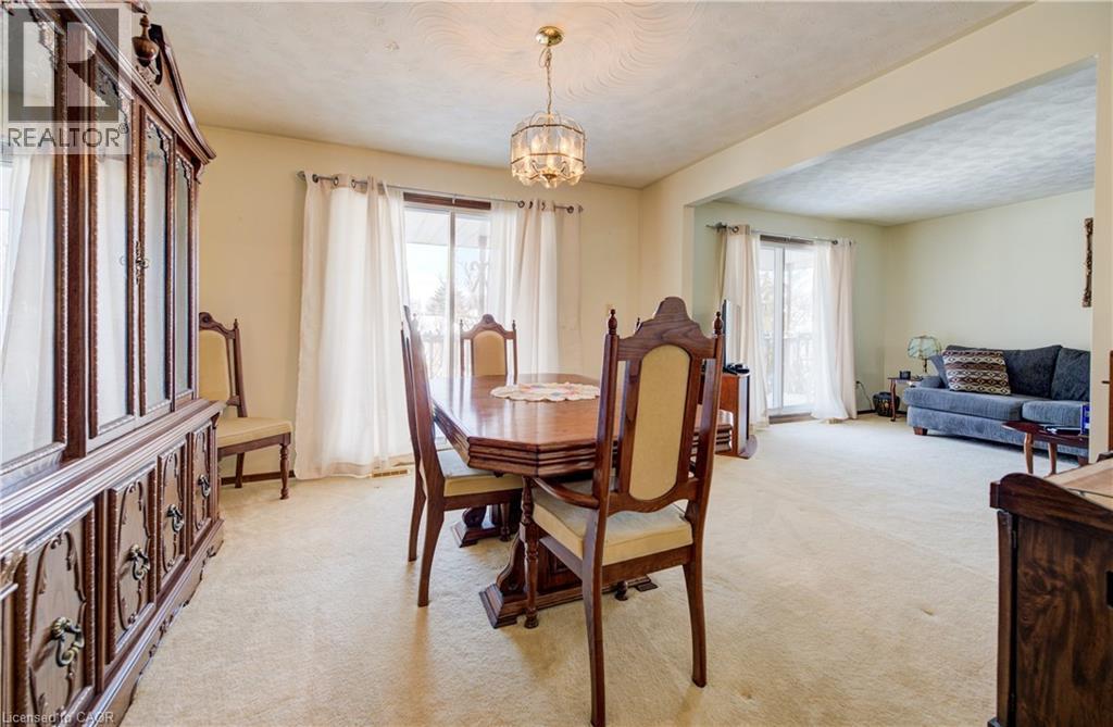 Dining area with light carpet, a chandelier, and a textured ceiling - 42 Ruffian Road, Brantford, ON - Indoor Photo Showing Dining Room