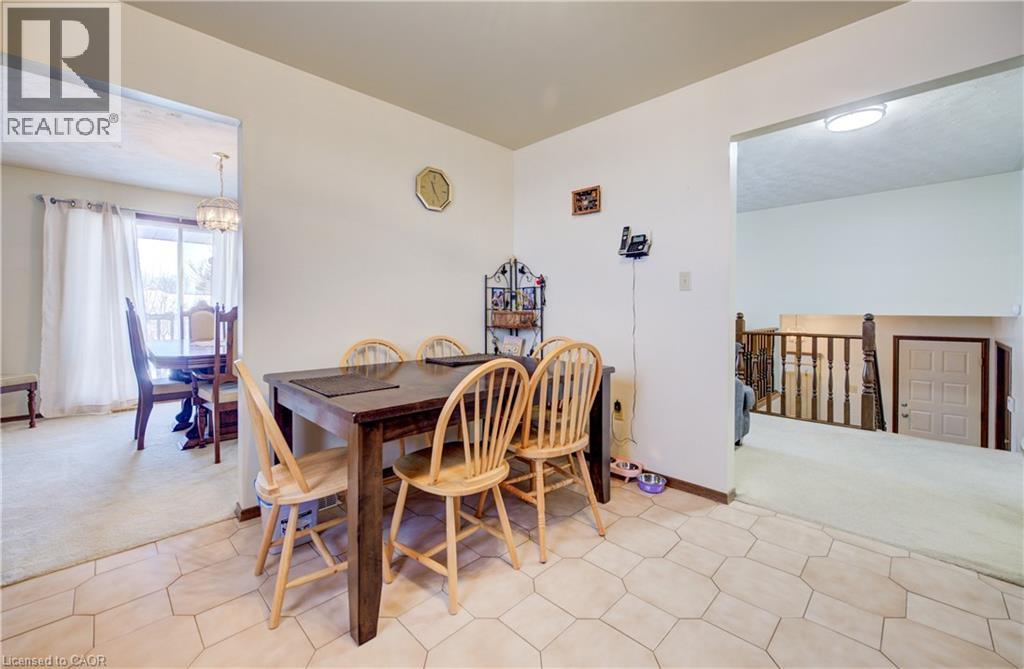 Dining room with light colored carpet and a chandelier - 42 Ruffian Road, Brantford, ON - Indoor Photo Showing Dining Room