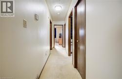 Hall featuring light carpet and baseboards -