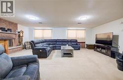 Carpeted recreation/family room with a textured ceiling and a brick fireplace -