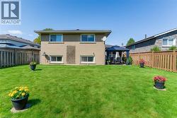 Back of property with a gazebo, a fenced backyard, brick siding, and a patio -