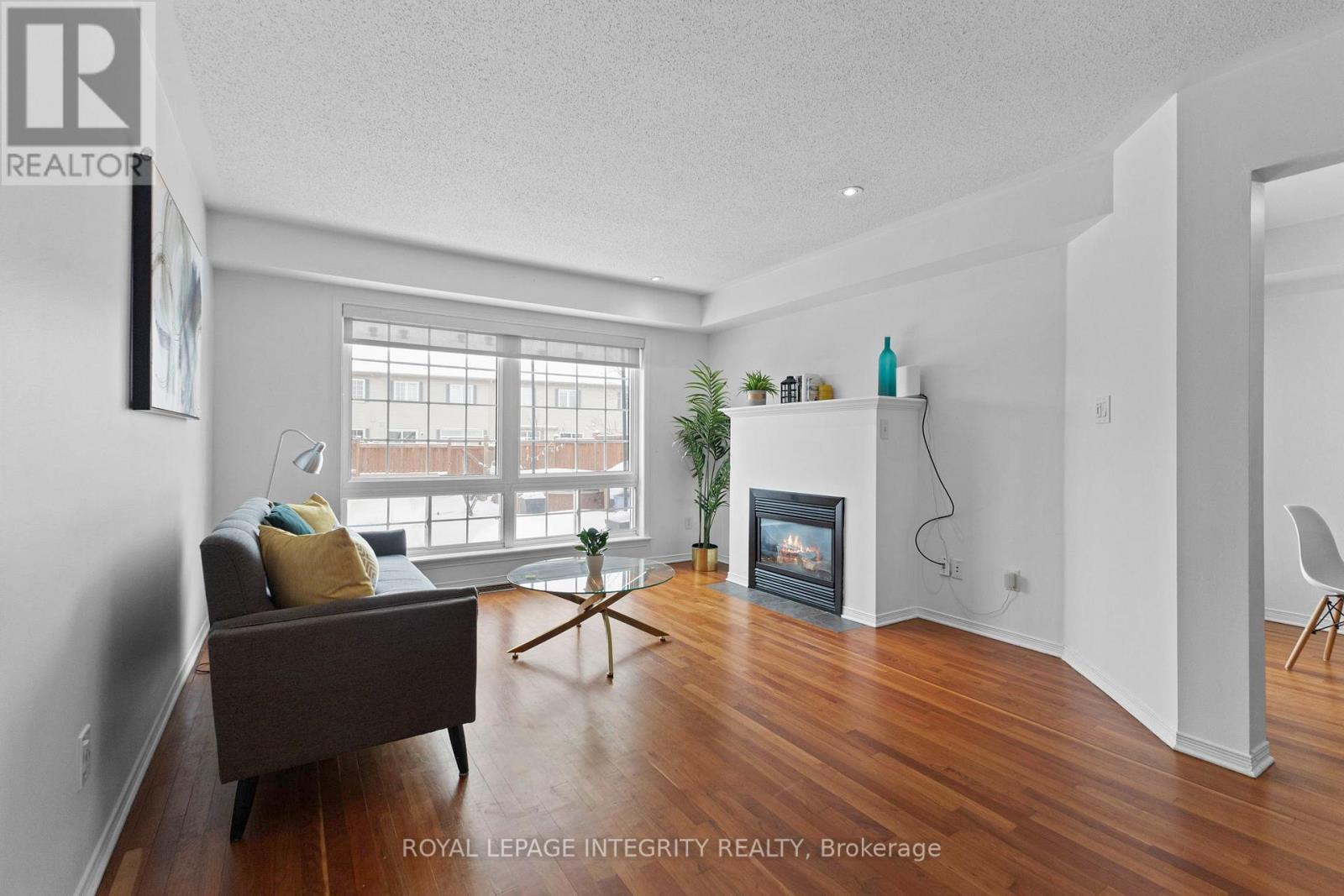 Living room with fireplace and backyard entry - 30 Goldthorpe Private, Ottawa, ON - Indoor Photo Showing Living Room With Fireplace