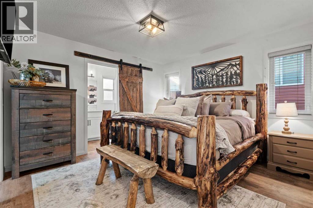 Master bedroom with walk in closet - 311 Mcleod Crescent, Diamond Valley, AB - Indoor Photo Showing Bedroom
