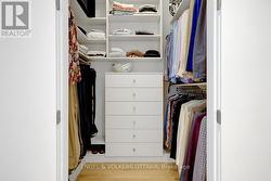 Primary walk-in closet with custom cabinetry -