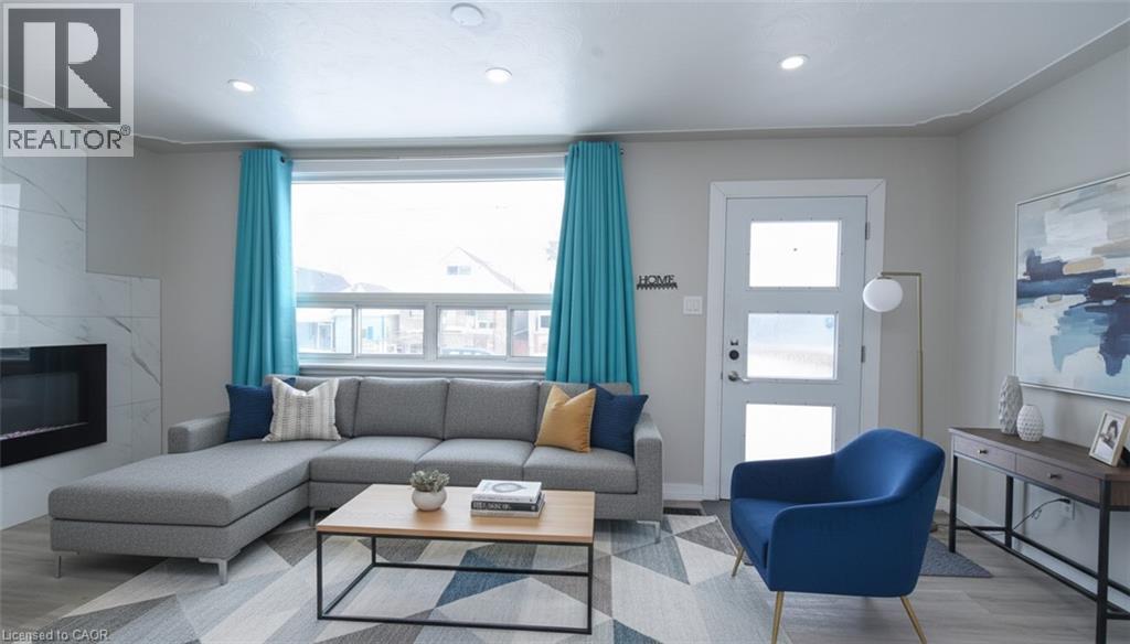 Living area featuring a premium fireplace, wood finished floors, and recessed lighting - 371 Fairfield Avenue, Hamilton, ON - Indoor Photo Showing Living Room With Fireplace