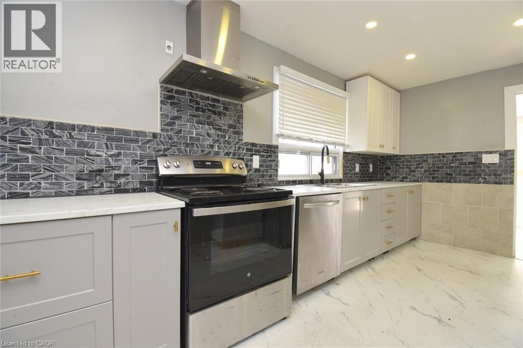 Kitchen with appliances with stainless steel finishes, island range hood, recessed lighting, light stone countertops, and light marble finish flooring - 371 Fairfield Avenue, Hamilton, ON - Indoor Photo Showing Kitchen With Upgraded Kitchen
