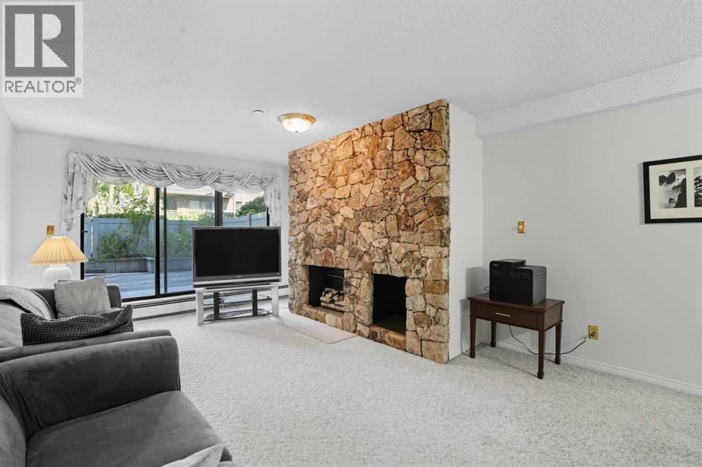109, 3730 50 Street Nw, Calgary, AB - Indoor Photo Showing Living Room With Fireplace