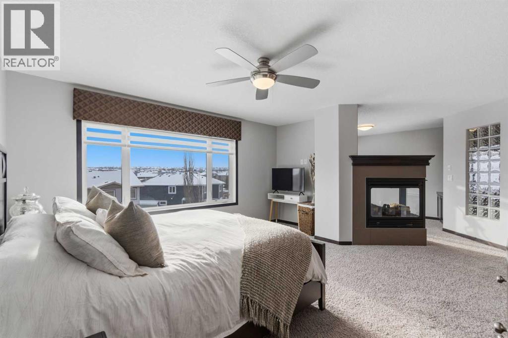 71 Panatella View Nw, Calgary, AB - Indoor Photo Showing Bedroom With Fireplace