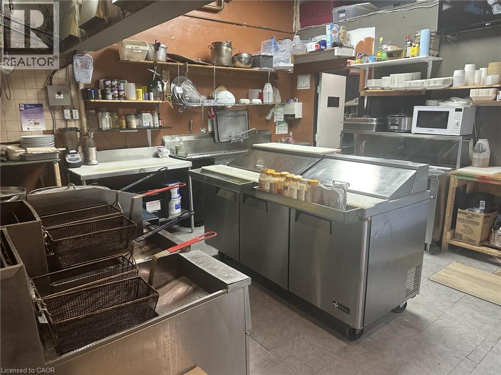 Kitchen with white microwave and open shelves - 597 King Street, Hamilton, ON