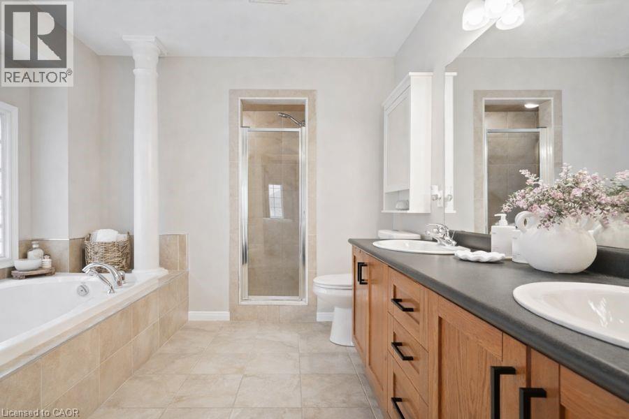 Bathroom featuring a stall shower, double vanity, a bath, and light tile patterned floors - 151 Fair Street, Ancaster, ON