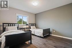Bedroom featuring dark wood finished floors and baseboards -