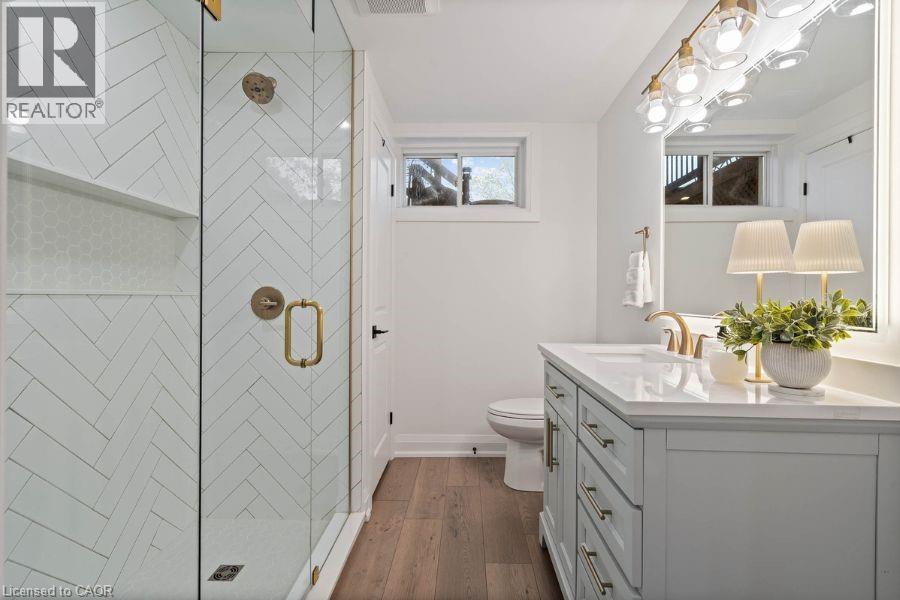 Bathroom featuring a stall shower, vanity, and dark wood-type flooring - 151 Fair Street, Ancaster, ON