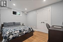 Bedroom with light wood-style floors, recessed lighting, and a desk -