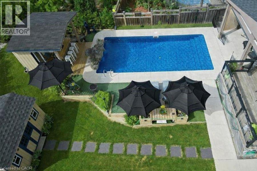View of swimming pool with a fenced backyard, a patio, and an outdoor structure - 151 Fair Street, Ancaster, ON