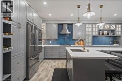 Kitchen featuring open shelves, gray cabinets, a breakfast bar, hanging light fixtures, and crown molding -