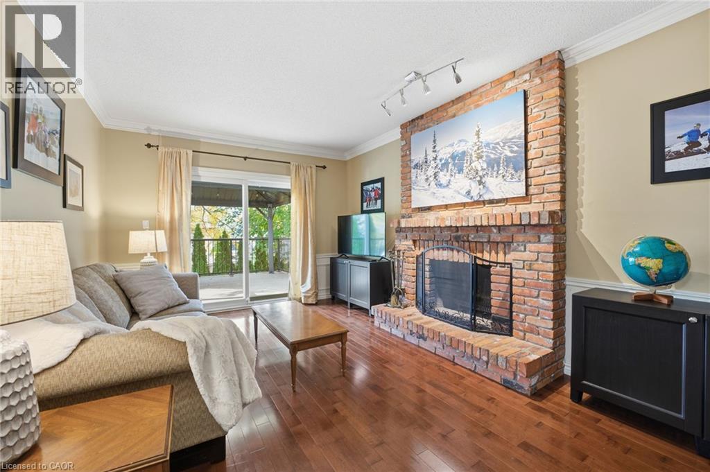 Back family room with sliding door onto composite deck with gazebo - 84 Chatterson Drive, Ancaster, ON - Indoor Photo Showing Living Room With Fireplace