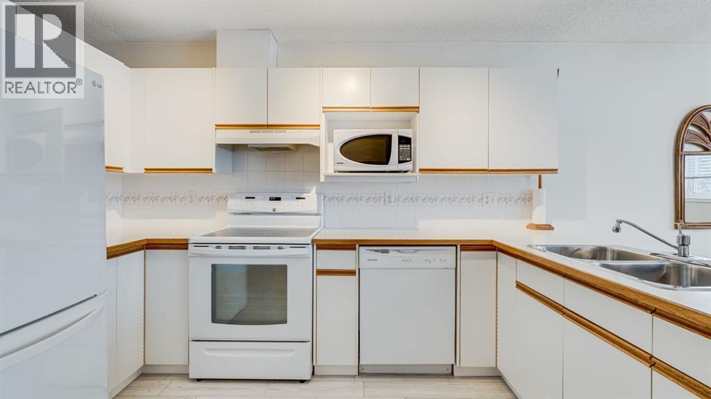 Lots of cupboards - 42, 105 Elm Place, Okotoks, AB - Indoor Photo Showing Kitchen With Double Sink