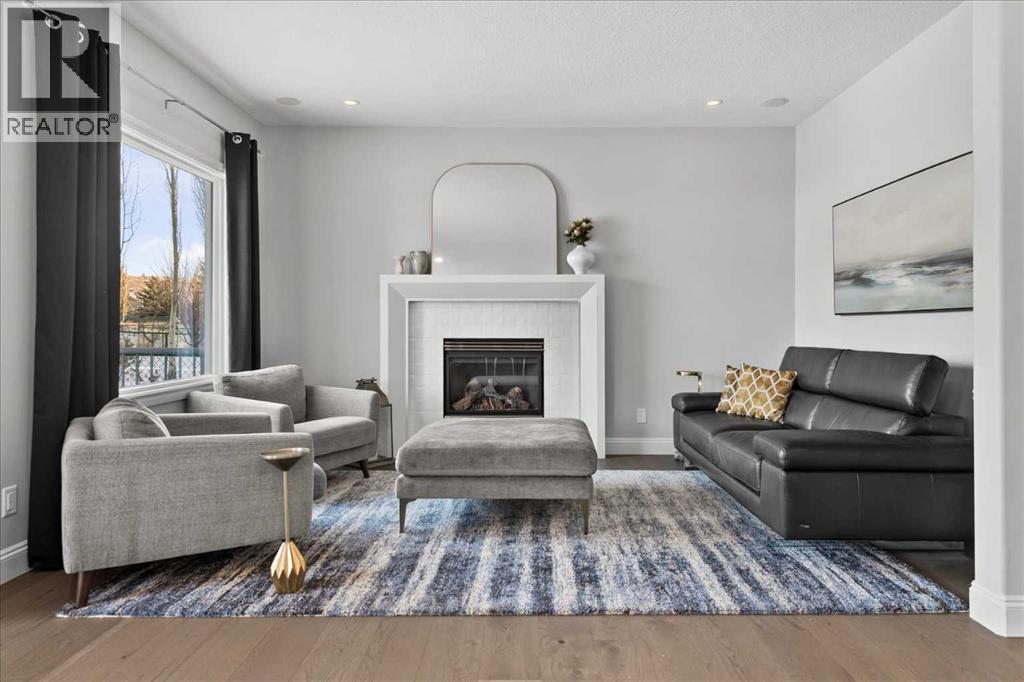 Main floor living area - 255 Gleneagles View, Cochrane, AB - Indoor Photo Showing Living Room With Fireplace