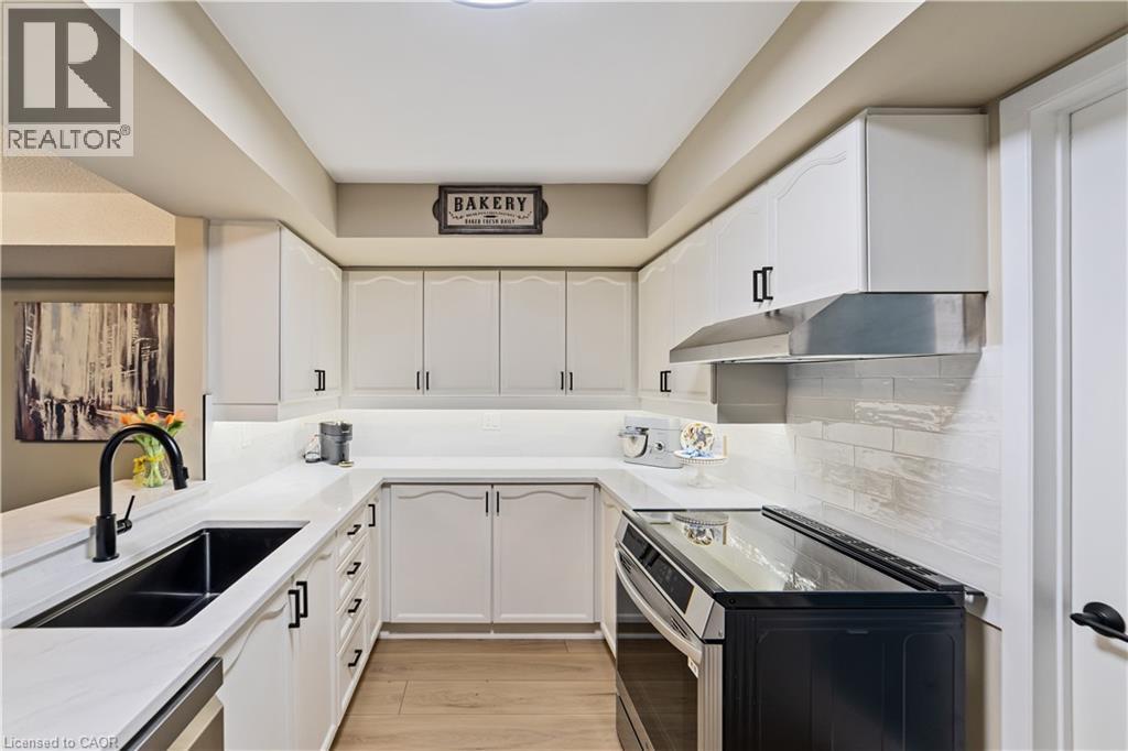 Updated kitchen features classic white cabinetry - 216 Plains Road W Unit# B403, Burlington, ON - Indoor Photo Showing Kitchen With Double Sink