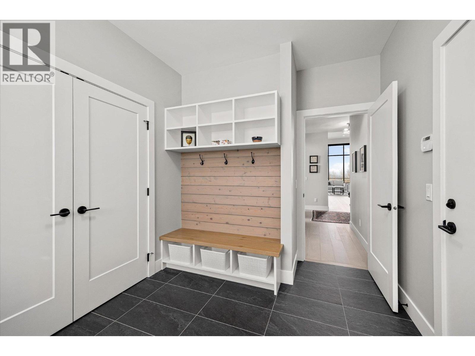 A great zone with lots of storage, a closet and a built-in bench, hooks & shelves. - 468 Sparrow Hawk Court, Kelowna, BC - Indoor Photo Showing Other Room