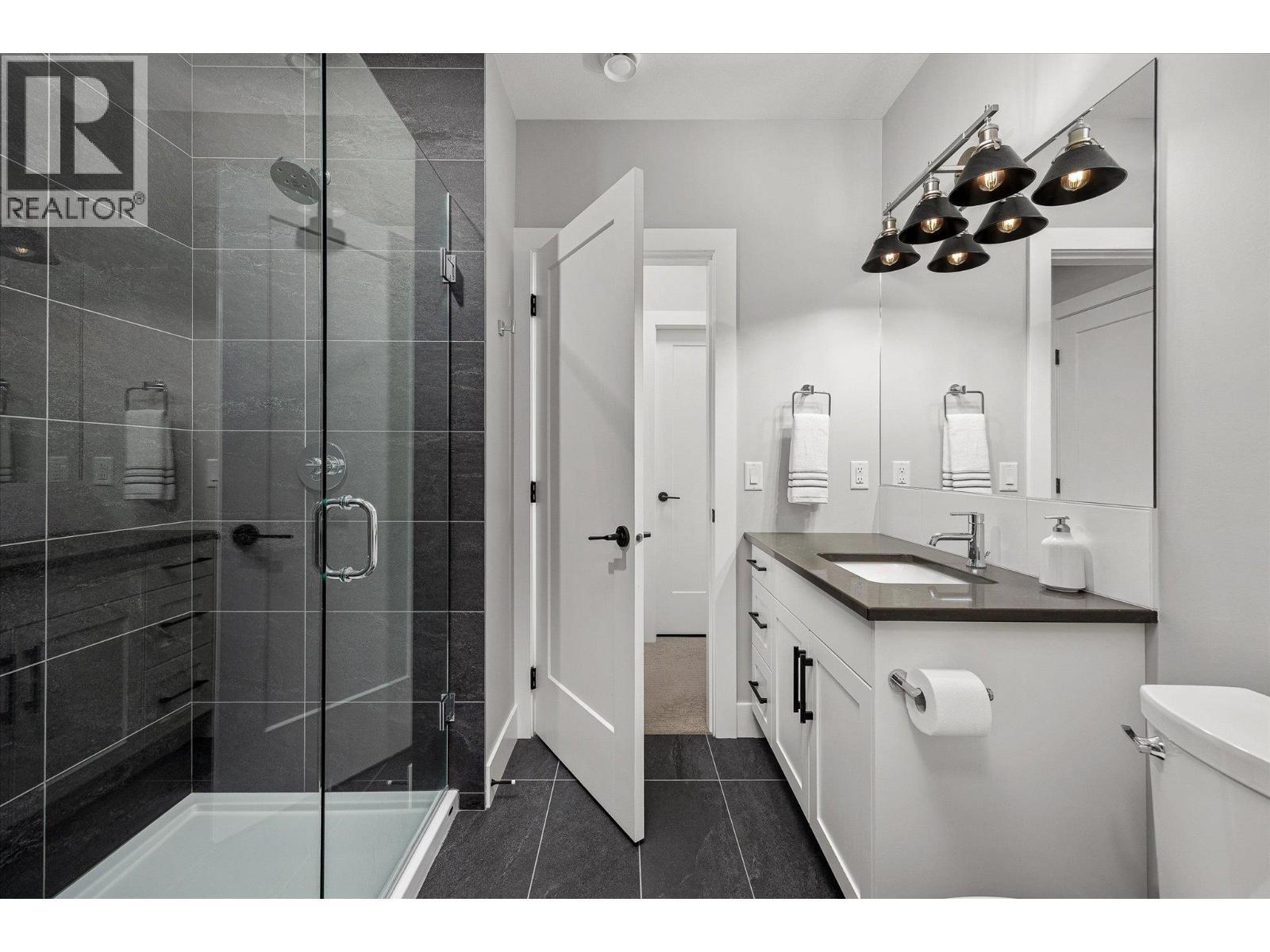 3-piece with large walk-in glass & tile shower, quartz surfaces and coordinating tile floors - 468 Sparrow Hawk Court, Kelowna, BC - Indoor Photo Showing Bathroom