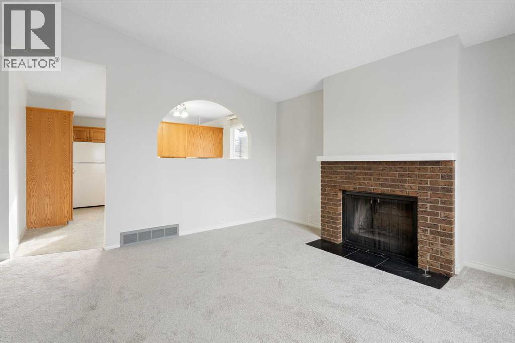 987 Berkley Drive Nw, Calgary, AB - Indoor Photo Showing Living Room With Fireplace