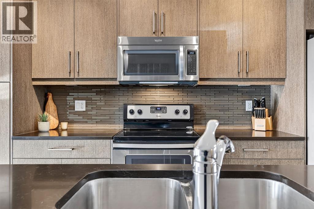 Under cabinet lighting - 330 Marquis Lane Se, Calgary, AB - Indoor Photo Showing Kitchen With Stainless Steel Kitchen With Double Sink With Upgraded Kitchen