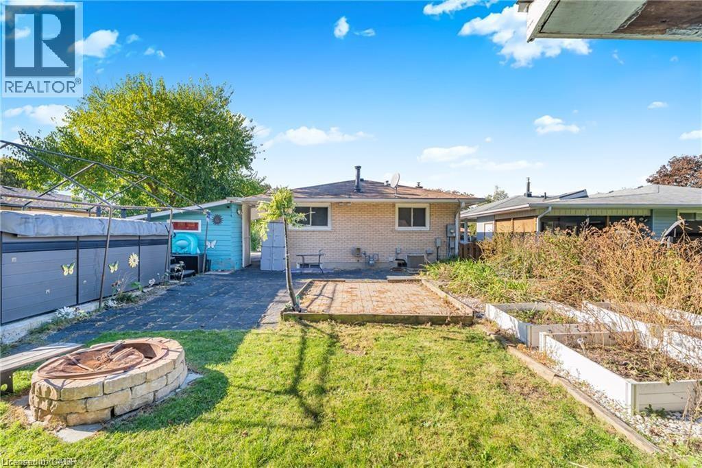 Back of house featuring a patio, an outdoor fire pit, brick siding, and a vegetable garden - 146 Appalachian Crescent Unit# Lower, Kitchener, ON - Outdoor