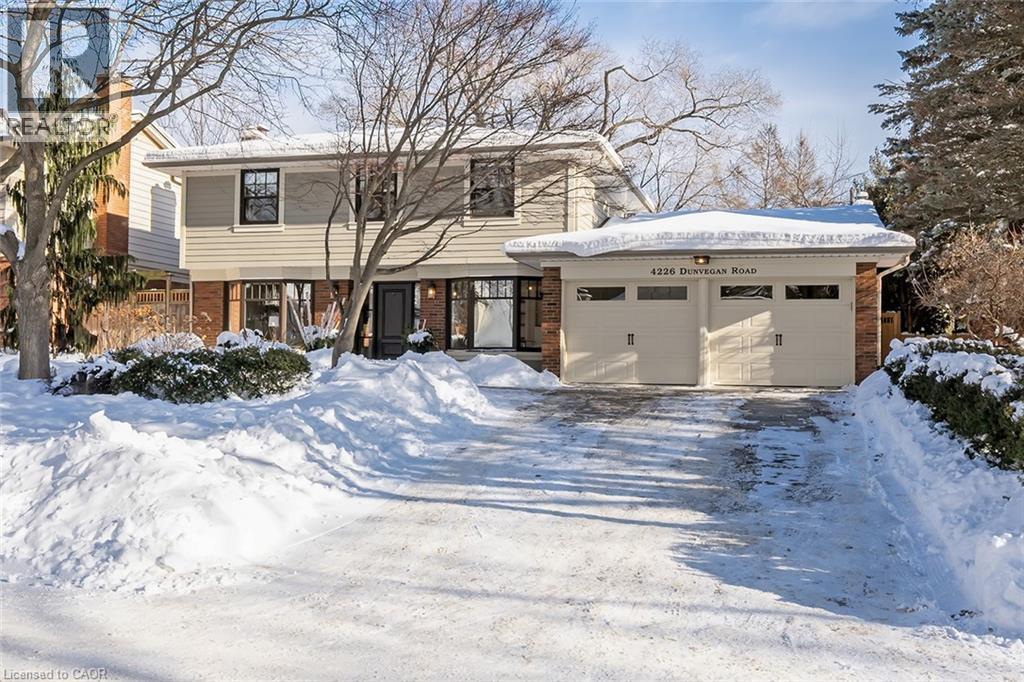View of front of home featuring brick siding, an attached garage, and driveway - 4226 Dunvegan Road, Burlington, ON - Outdoor