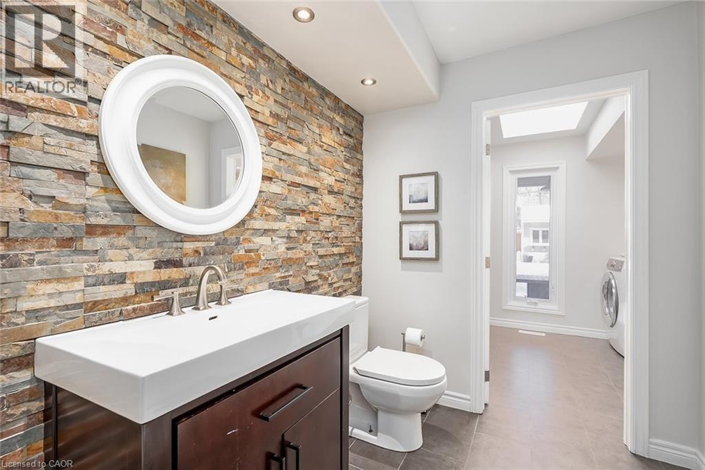 Half bathroom with vanity, washer / clothes dryer, tile patterned floors, and recessed lighting - 4226 Dunvegan Road, Burlington, ON - Indoor Photo Showing Bathroom