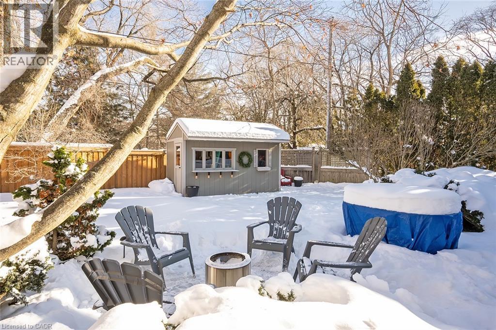 Yard layered in snow featuring an outdoor structure and a fenced backyard - 4226 Dunvegan Road, Burlington, ON - Outdoor