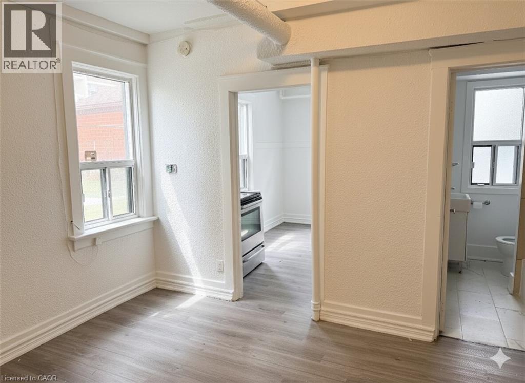 Hallway with a textured wall and light wood-style floors - 46 College Street, Kitchener, ON - Indoor Photo Showing Other Room