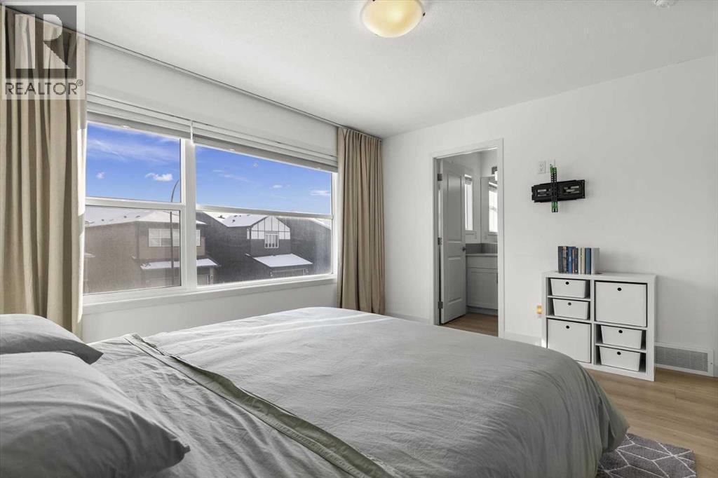 A serene primary suite designed as a private retreat, blending comfort, space, and quiet luxury - 59 Wolf Hollow Way Se, Calgary, AB - Indoor Photo Showing Bedroom