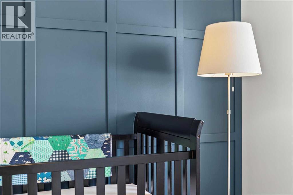 Thoughtful design details and soft lighting create a calm, welcoming feel ideal for a nursery or guest room - 59 Wolf Hollow Way Se, Calgary, AB - Photo Showing Bedroom