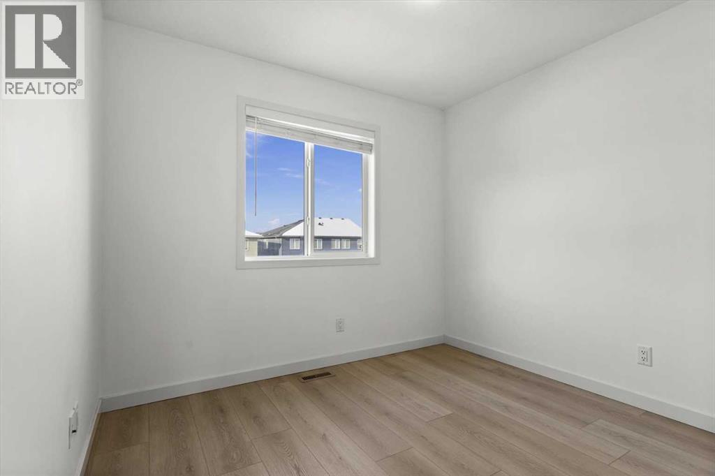 The third upper-level bedroom offers a versatile layout suitable for family living or a home office - 59 Wolf Hollow Way Se, Calgary, AB - Indoor Photo Showing Other Room
