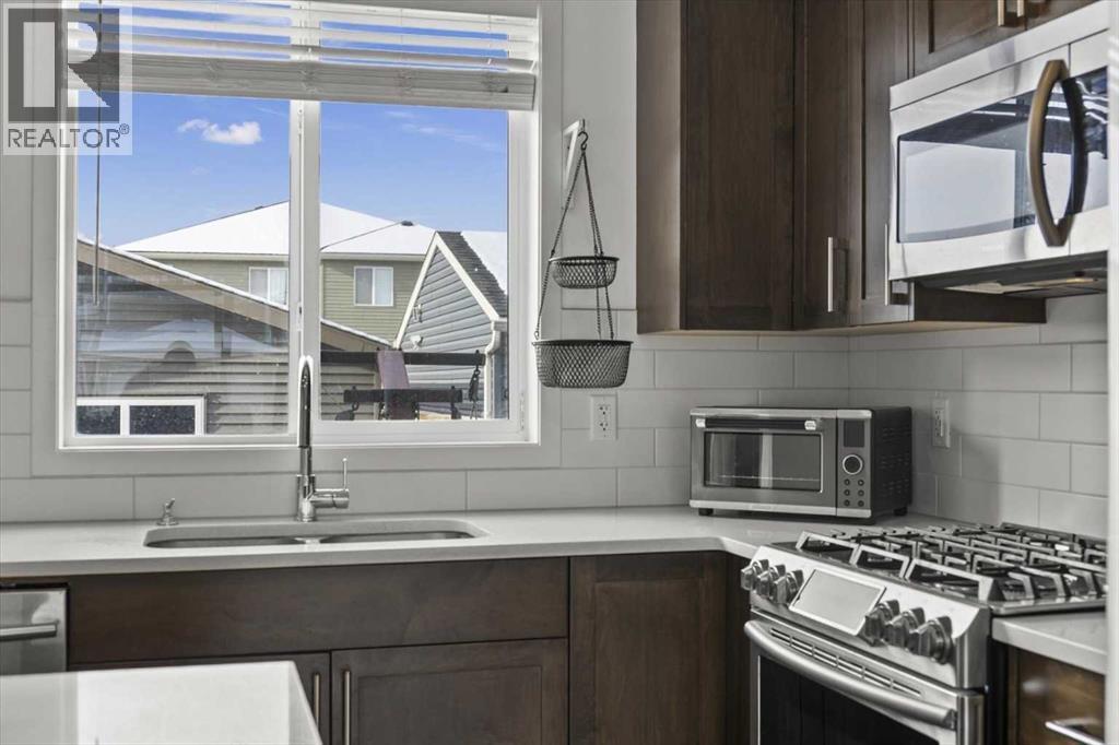 This one even has the coveted kitchen window over the under mount sink! - 59 Wolf Hollow Way Se, Calgary, AB - Indoor Photo Showing Kitchen With Stainless Steel Kitchen With Double Sink With Upgraded Kitchen