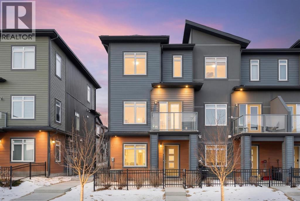 Front view, balcony, fenced concrete patio, poured concrete walk - 217 Sage Bluff Drive Nw, Calgary, AB - Outdoor With Balcony With Facade