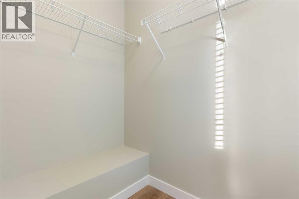 Front primary bedroom with walk-in closet - 217 Sage Bluff Drive Nw, Calgary, AB - Indoor With Storage