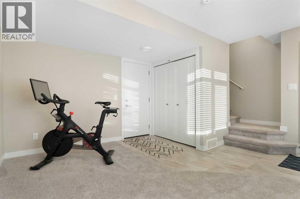Flex room, entrance to garage, utility room - 217 Sage Bluff Drive Nw, Calgary, AB - Indoor Photo Showing Gym Room