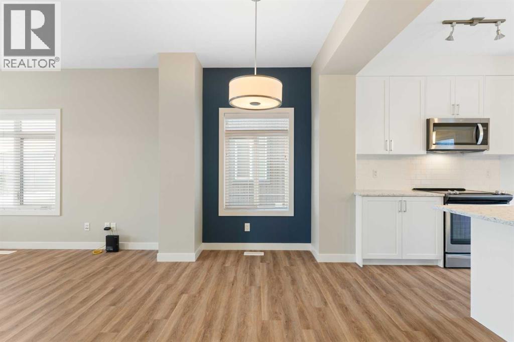 Dining room with feature wall, chandelier - 217 Sage Bluff Drive Nw, Calgary, AB - Indoor Photo Showing Kitchen