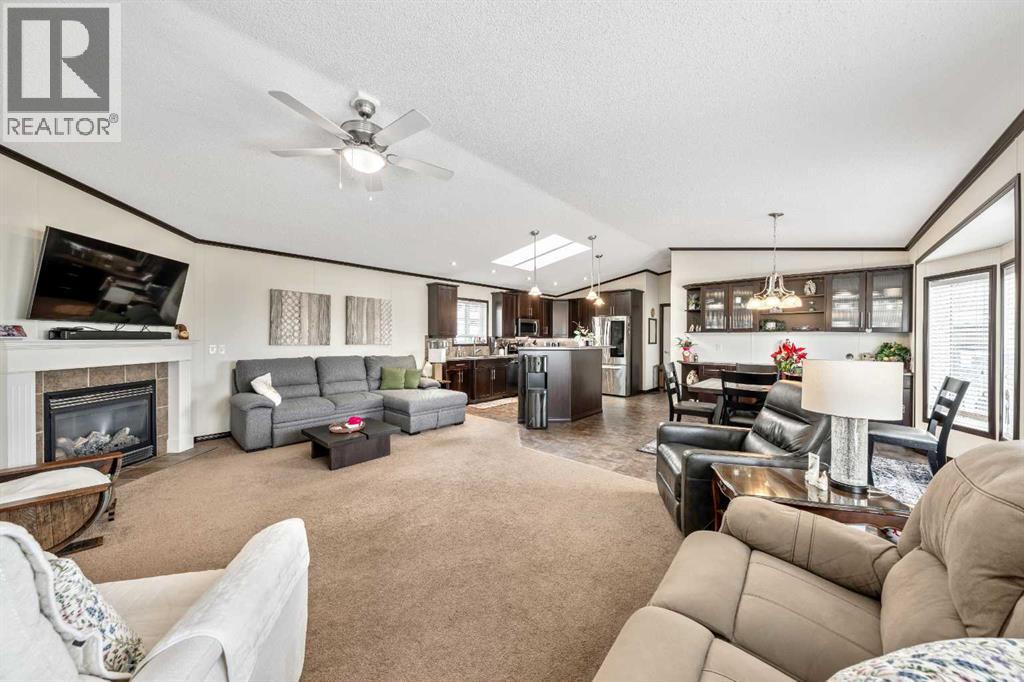 Come On In! - 4 Spring Dale Circle Se, Airdrie, AB - Indoor Photo Showing Living Room With Fireplace